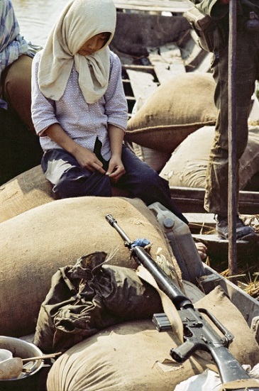 Une jeune fille attend d'être "relocalisée" par l'armée sud-vietnamienne. Cette stratégie de terre brûlée avait pour but de priver le Viêt-Cong de l'aide de la population. Les civils étaient déplacés vers des "hameaux protégés".